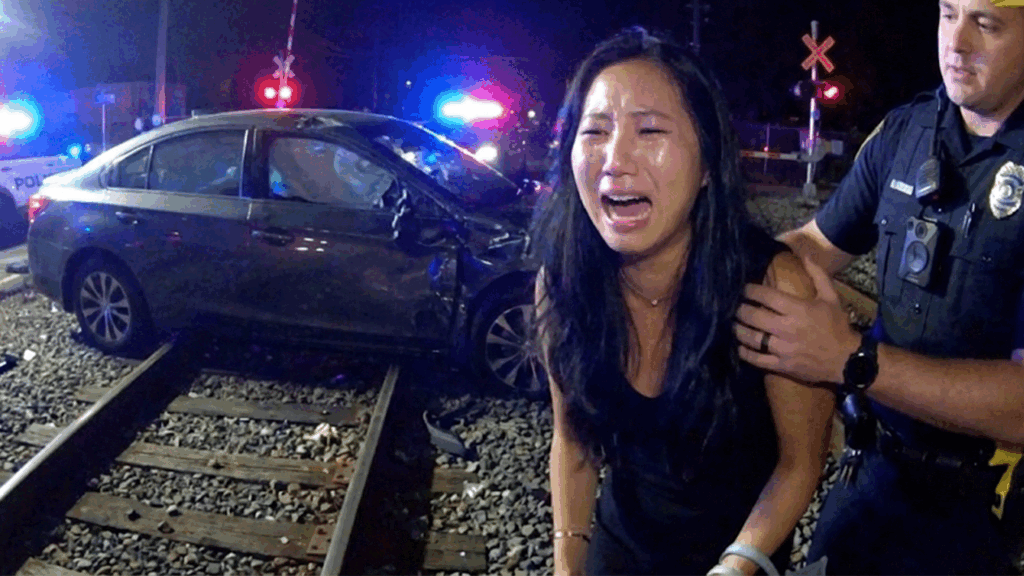 Athens DUI Arrest showing officers questioning a suspect near train tracks.