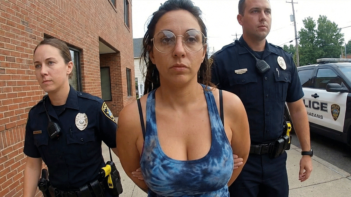 Target Shoplifting Arrest showing Middletown police officers questioning a female suspect near a vehicle.